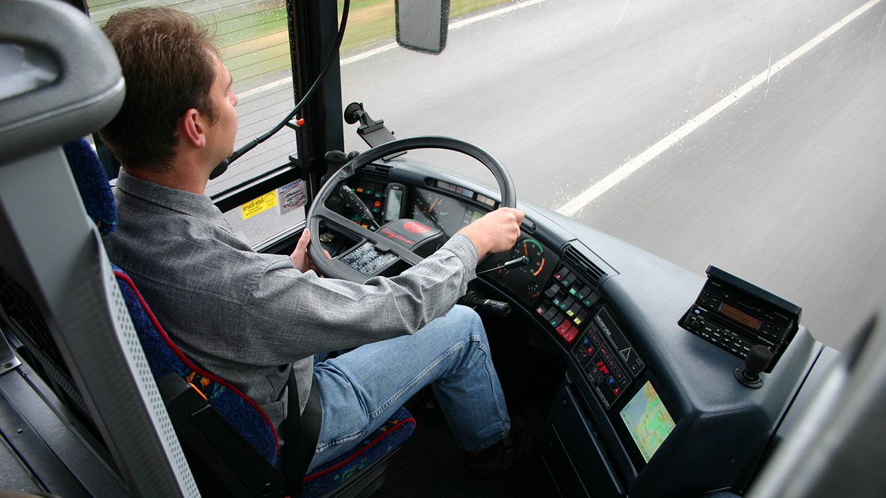 Ein Busfahrer am Steuer eines Busses.