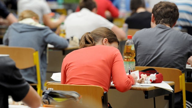 Schüler sitzen an Tischen und lernen.