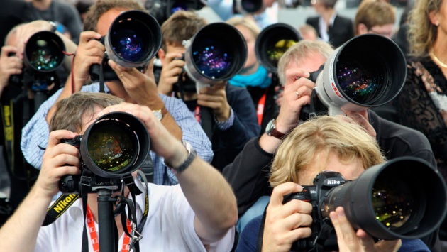 Fotografen gucken auf einer Pressekonferenz durch ihre Kameras.