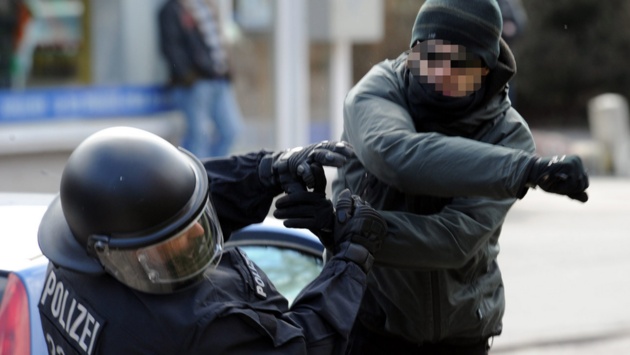 Ein gewalttätiger Demonstrant schlägt in Lübeck einen Polizeibeamten nieder.