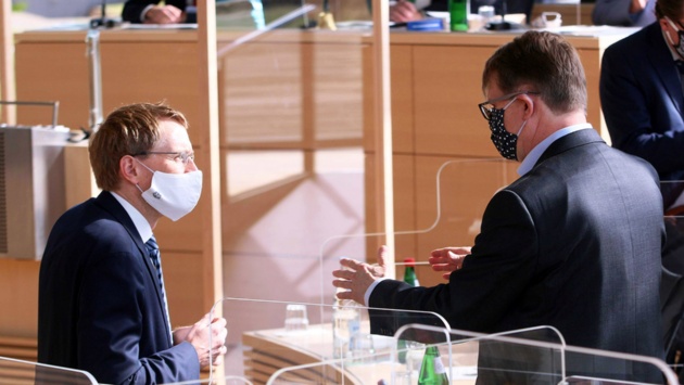 Vor der Eröffnung der Plenartagung sprechen Ministerpräsident Daniel Günther (CDU) und Oppositionsführer Ralf Stegner (SPD) stehend miteinander.