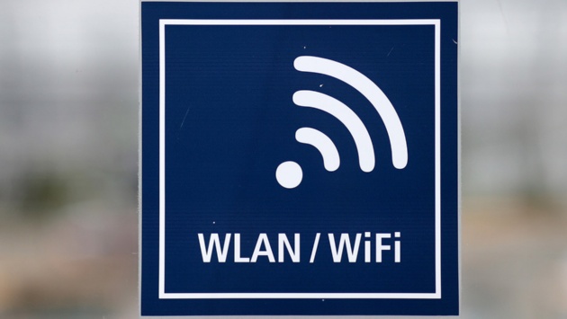 Ein Aufkleber mit der Aufschrift „Wlan/Wifi“ an einer Tür.