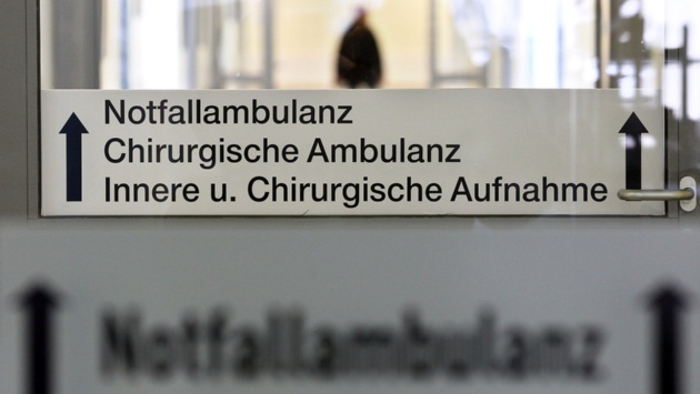 Schilder weisen den Weg zur Notfallambulanz in einem Krankenhaus.