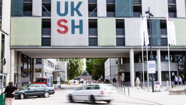 Das Logo des Universitätsklinikums Schleswig-Holstein ist am Klinik-Eingang angebracht.