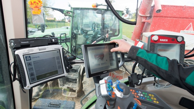 Ein Landwirt bedient ein digitales Steuerelement für Düngemittel.