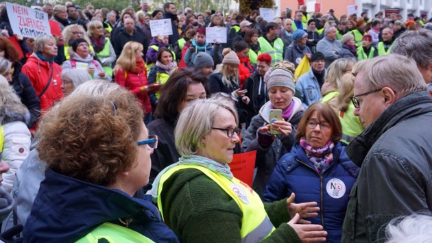 Der Vorsitzende des Sozialausschusses Werner Kalinka diskutiert mit mehreren Demonstranten.